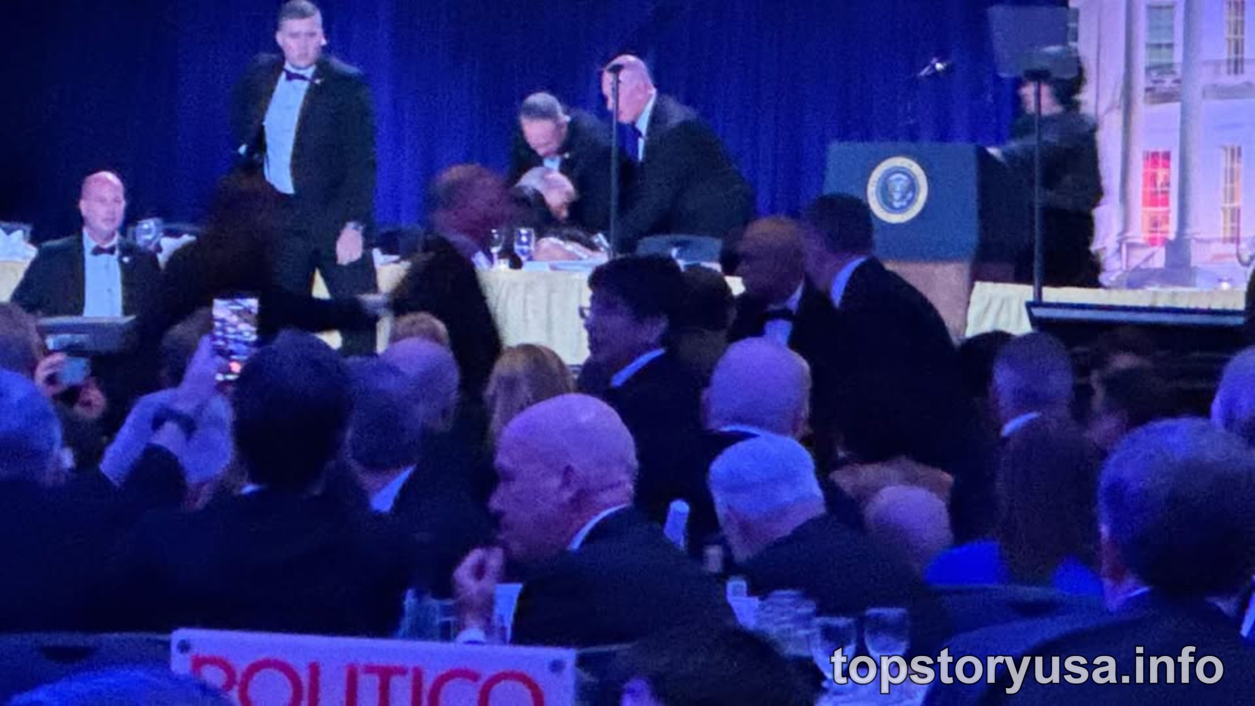 Trump addresses crowd at White House Correspondents Dinner event with presidential seal visible on podium