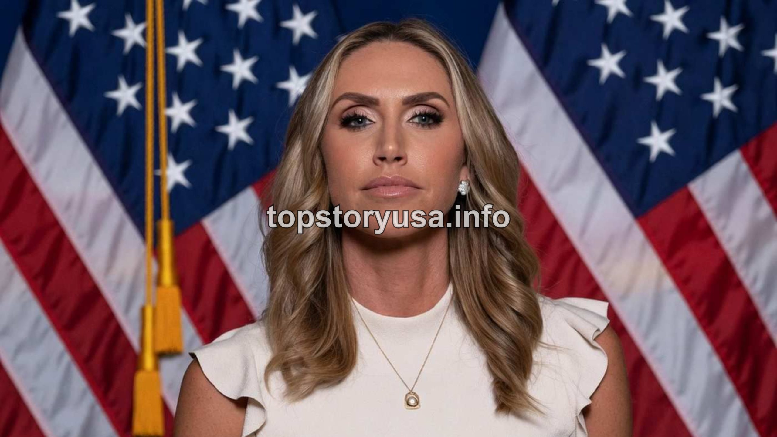 Lara Trump RNC Co-Chair portrait with American flags background in professional white sleeveless top